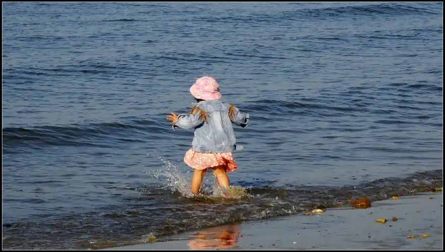 抓拍海边玩水的一小小女孩
