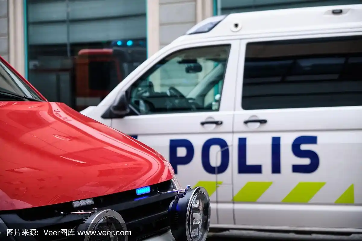 在芬兰的街道上,一辆带蓝色灯的消防车和一辆警车.