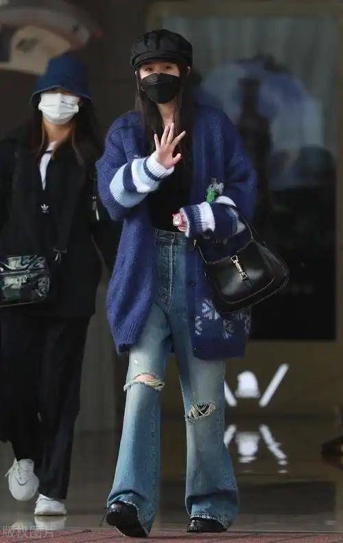 杨幂穿喇叭牛仔裤搭针织外套现身机场,行程匆忙不忘与粉丝打招呼