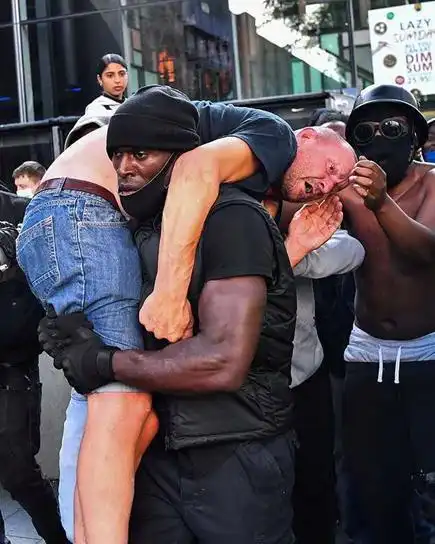 激烈冲突中,白人醉汉遭示威者拳打脚踢,黑人男子奋勇救人