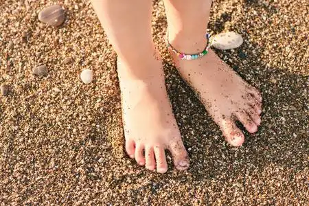 的小女孩一个小女孩脚上热带沙滩的特写可爱的小女孩,小脚赤脚跑步的