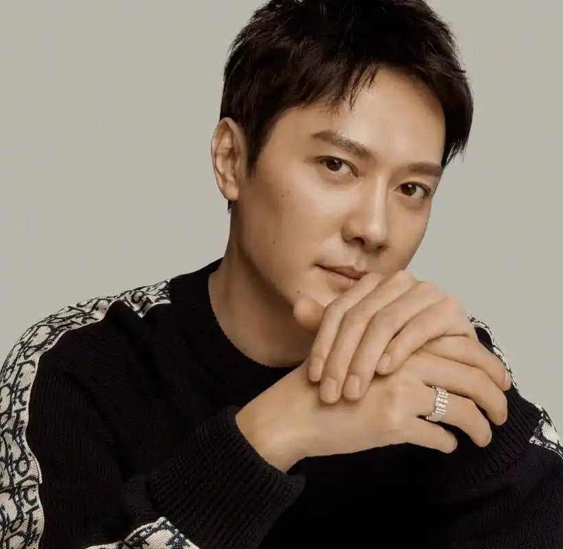 照片中冯绍峰身穿一件黑色的毛衣,做了简单的发型和妆容