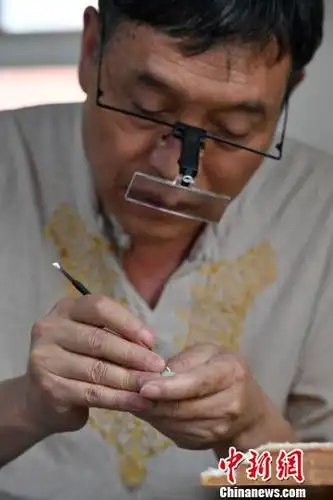 冉隆泉在进行微雕创作(刘冉阳摄)