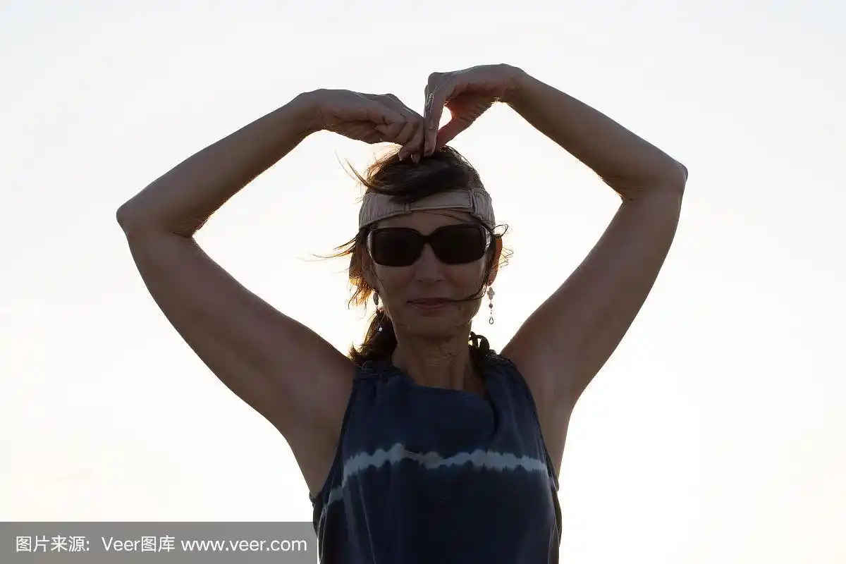 女孩在她的头上做一个心形