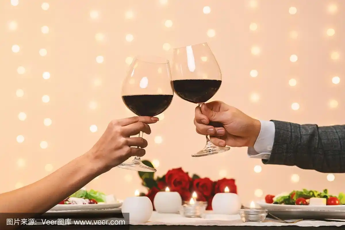 浪漫的情侣在餐厅约会时互相碰杯喝红酒