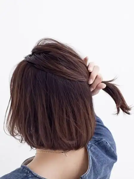 波波头蓬松凌乱,右侧的头发扭转成发辫后用发夹固定起来,清新减龄.