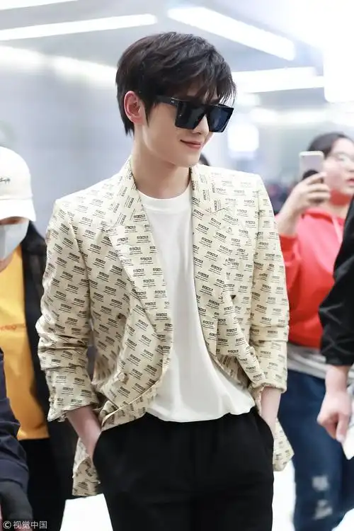 杨洋墨镜遮面穿字母西装手插兜露帅笑