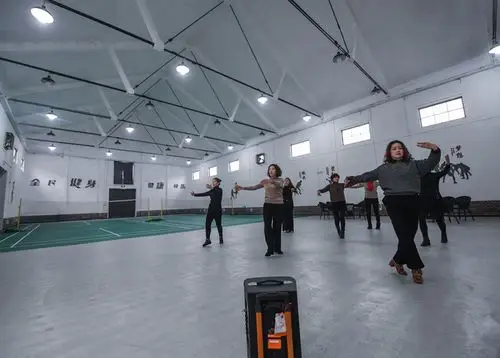 12月20日,村民们在旧粮仓改建的室内体育馆内排练广场舞.