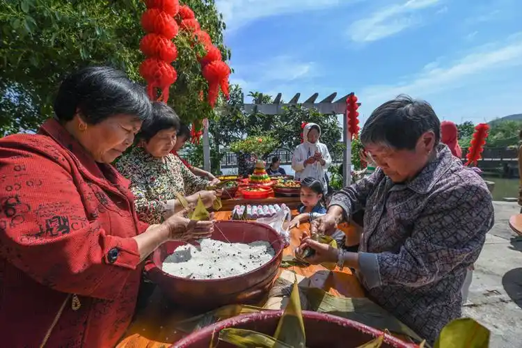 5月3日,丁山河村村民在活动现场包粽子.