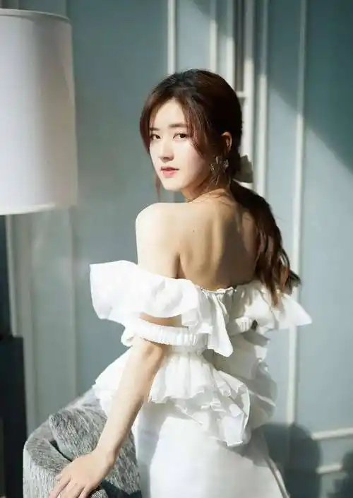 短裙是上下分开的款式,上身是一字肩的大荷叶边设计,衣服上沿一直拉低