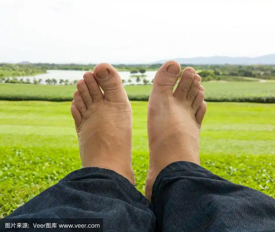 光着脚的男性正在草坪上休息