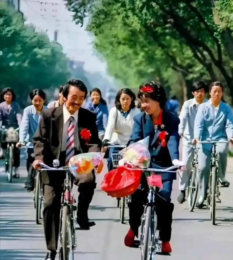 上个世纪80年代一对新婚夫妇的婚礼,两个人骑着自行车,脸上露出了幸福