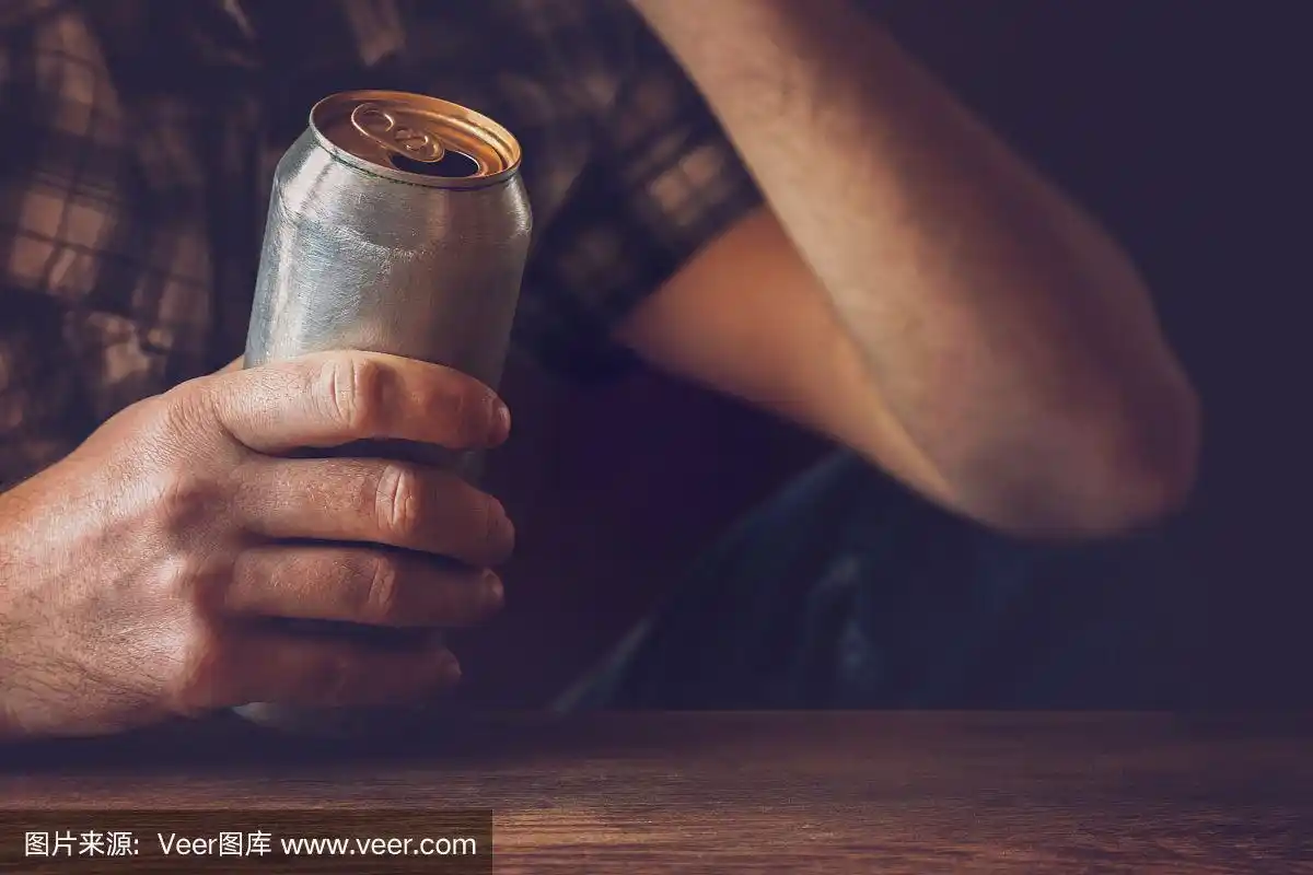 晚上下班后喝冰啤酒的男人.手里拿着一个铝罐.