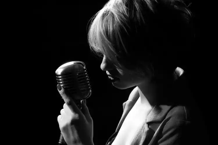 用麦克风唱歌的年轻女子