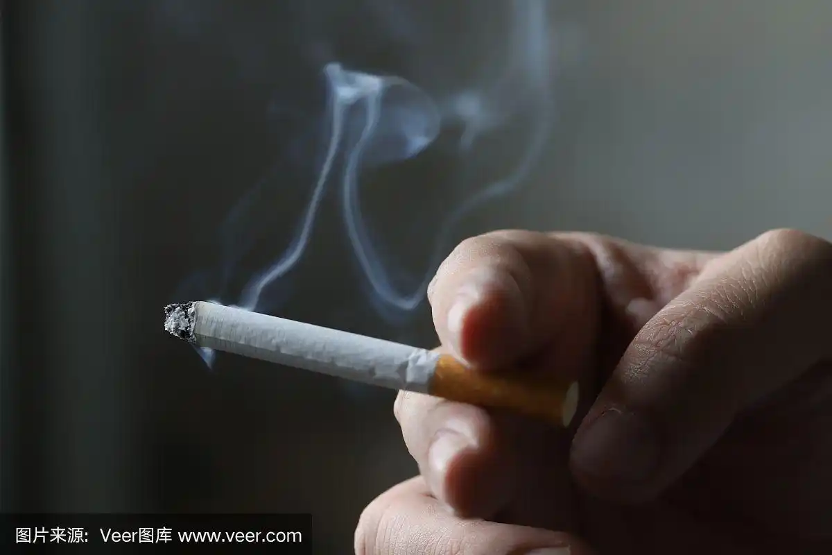 一个男人拿着一根烟的照片