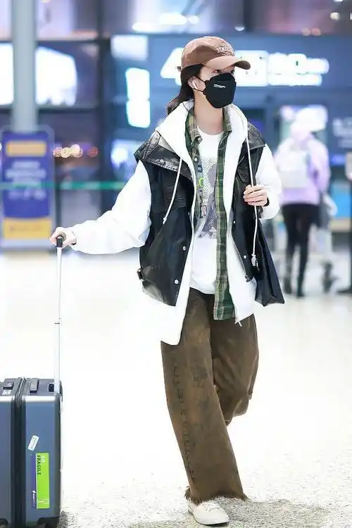 庄达菲穿黑色皮马甲内搭白色运动夹克搭配褐色牛仔裤随性休闲