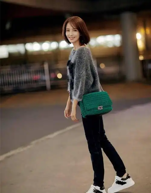 佟丽娅的时尚穿搭 佟丽娅穿着灰色v领毛衣搭配牛仔裤的造型简约而又