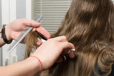 理发师用剪刀剪长头发, 后面是特写照片