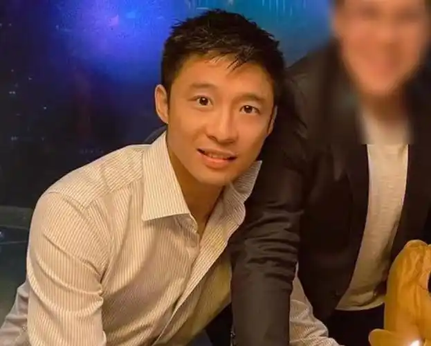 合影里的霍启山穿着一件细条纹白衬衫,一头干净利落的短发,一眼看过去