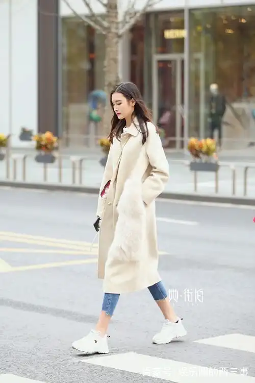米色风衣搭配牛仔紧身裤,尽显飘逸的灵动感