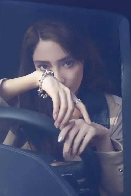 照片中,angelababy坐在汽车的驾驶座上,一头蓬松的长发,眼神炯炯有神