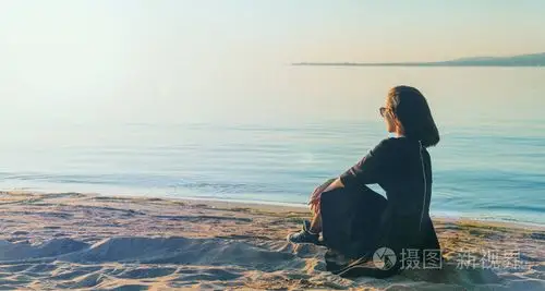 坐在海滩上的衣服的女人