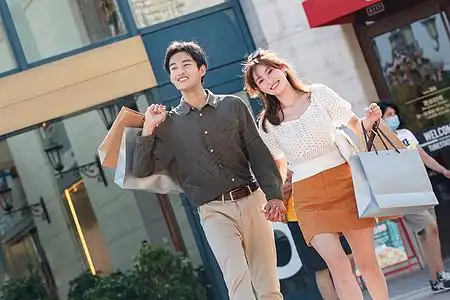 城市街道东亚幸福情侣手牵手逛街购物图片