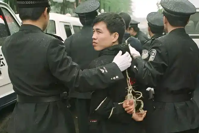 2008年,一名死刑犯正被送进囚车的照片,此时恋恋不舍的回望着