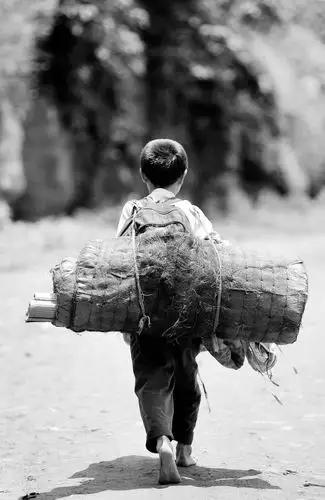 背着被褥,书包要走上三四个小时才能到家,为了省鞋,他们往往赤脚走路