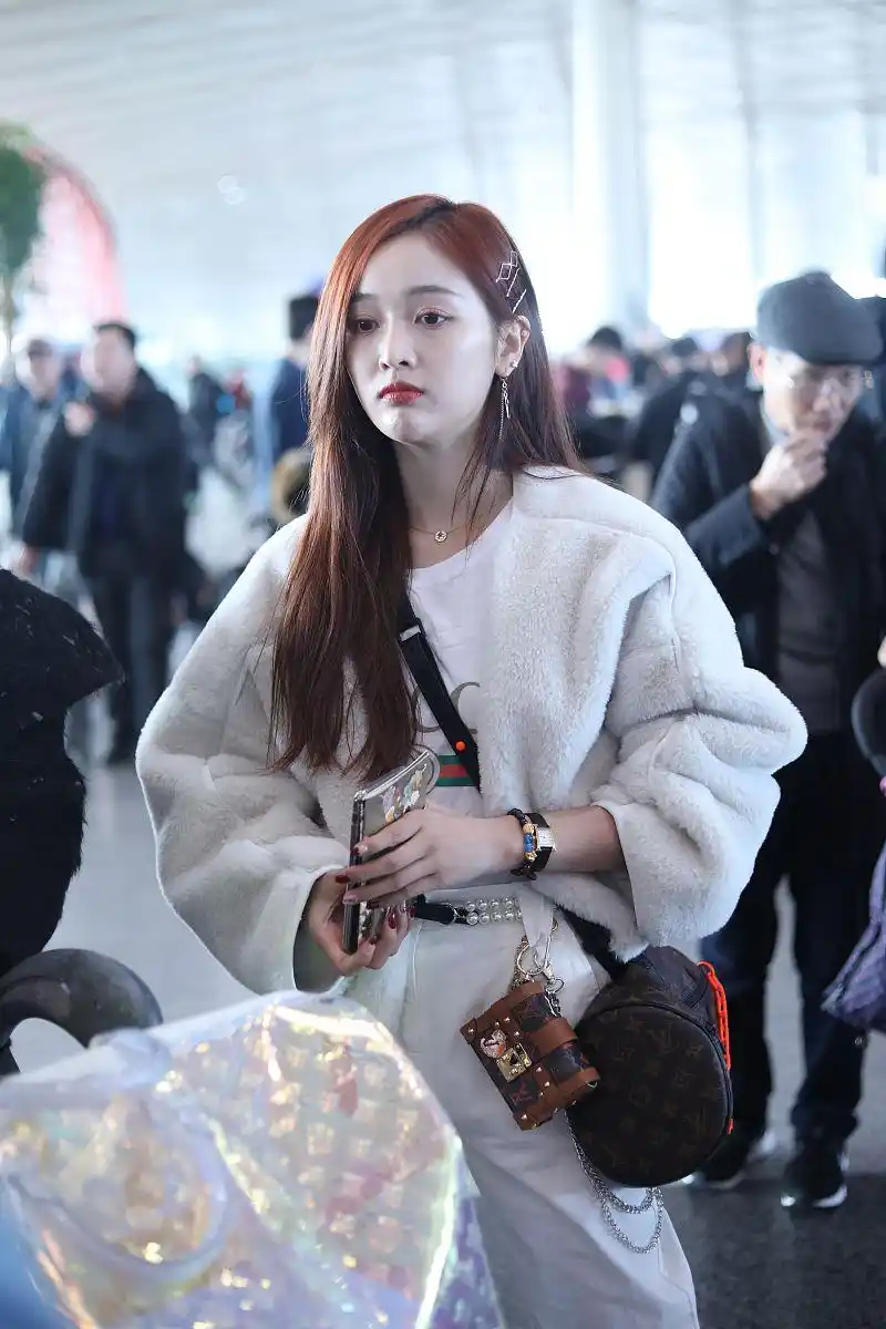 吴宣仪清新白色穿搭现身机场,毛绒外套凸显甜美优雅味