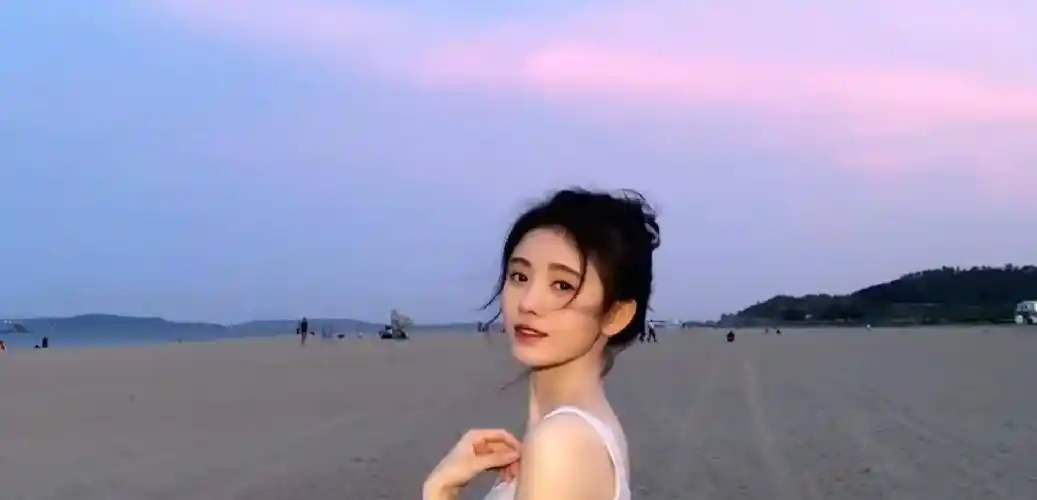 原创鞠婧祎穿白色背心海边漫步头发凌乱似韩系女主镜头下的直角肩堪称