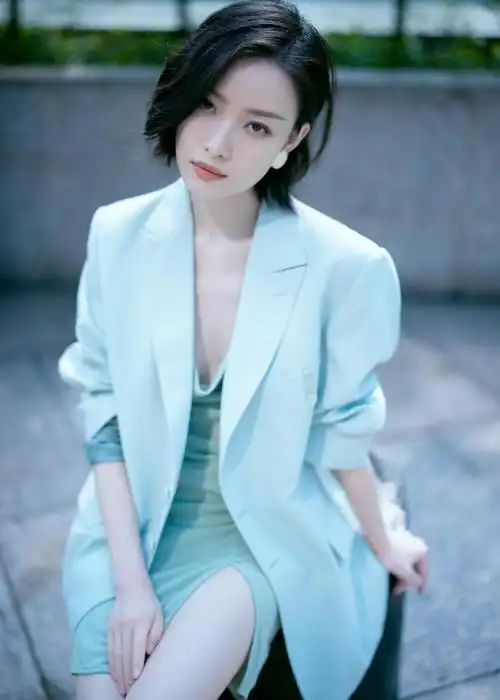倪妮穿了一件浅蓝色的西装内搭浅绿色的修身吊带连衣裙