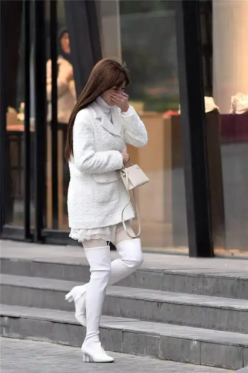 白色粗跟过膝靴,搭配白色丝袜,毛衣和外套都是白色的