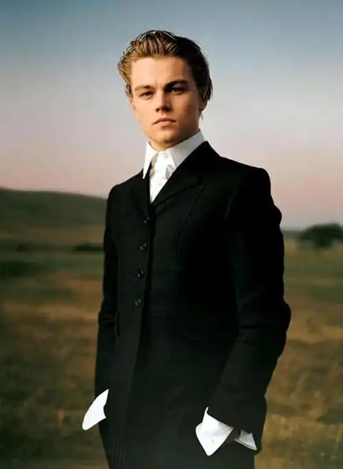 照片中的他一身妥帖的蓝色西服 白衫气质卓尔不群年轻时的小李子一