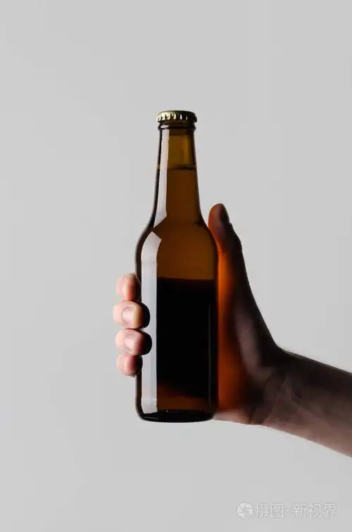 啤酒瓶模型-男性手拿着啤酒瓶在灰色背景上