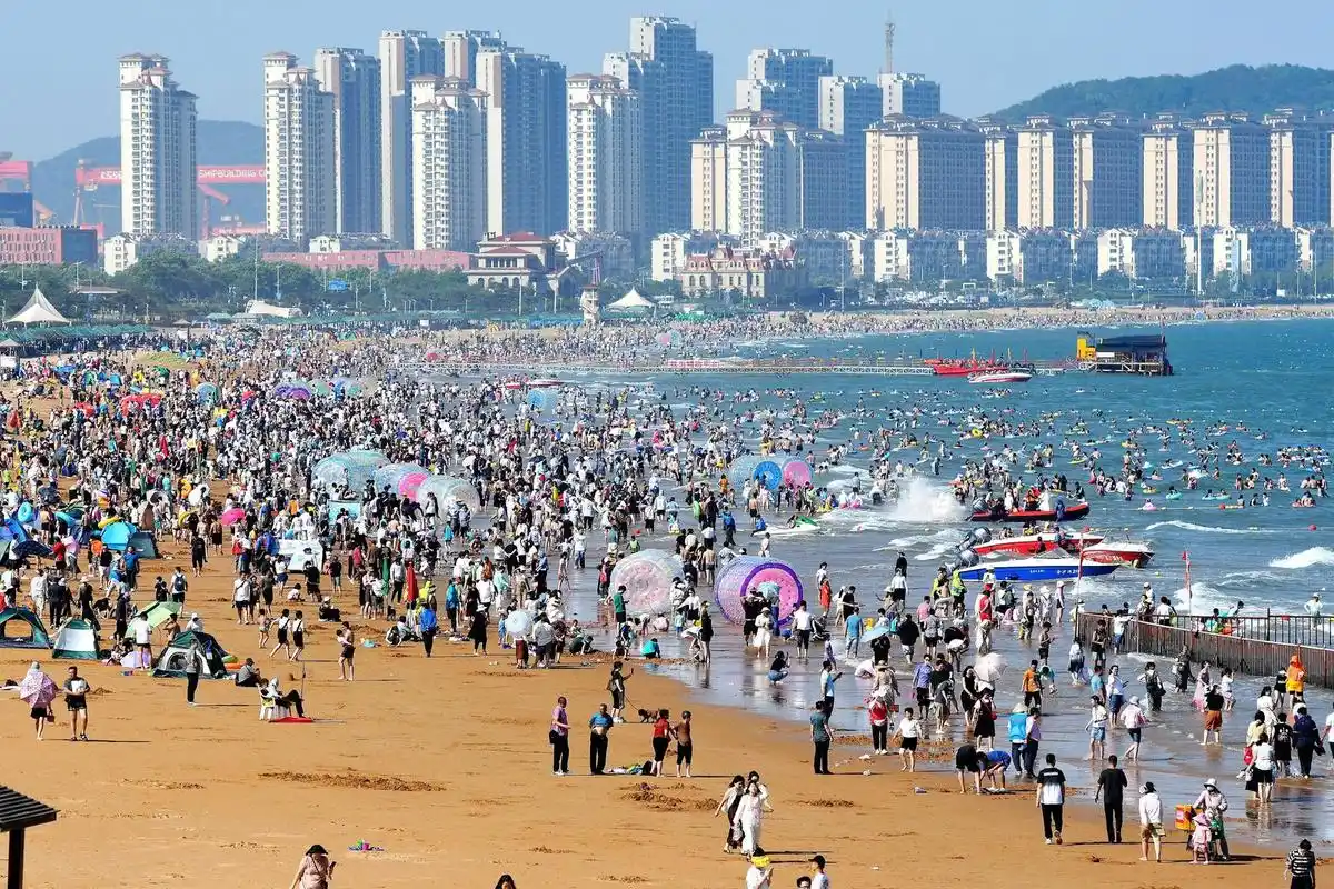 7月5日,青岛金沙滩海水浴场,游客在海滩亲水消夏 图据视觉中国