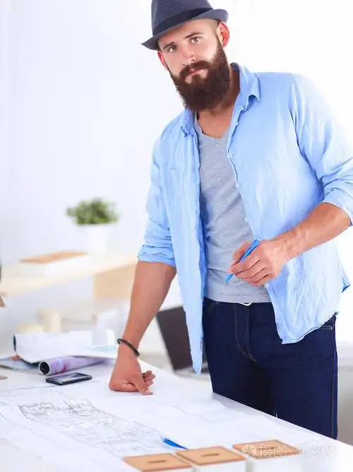 男性设计师在伏案蓝图带帽子的肖像