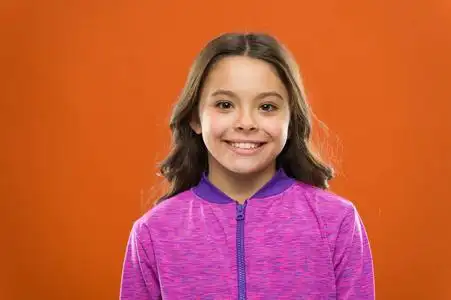 虚假的微笑和真诚的微笑有什么区别.女孩可爱的孩子快乐的笑脸.