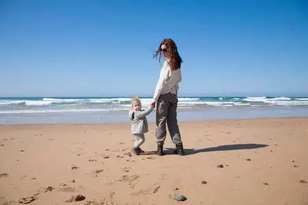 孕妇牵手在她的婴儿碰撞年轻情侣手牵手的背影.