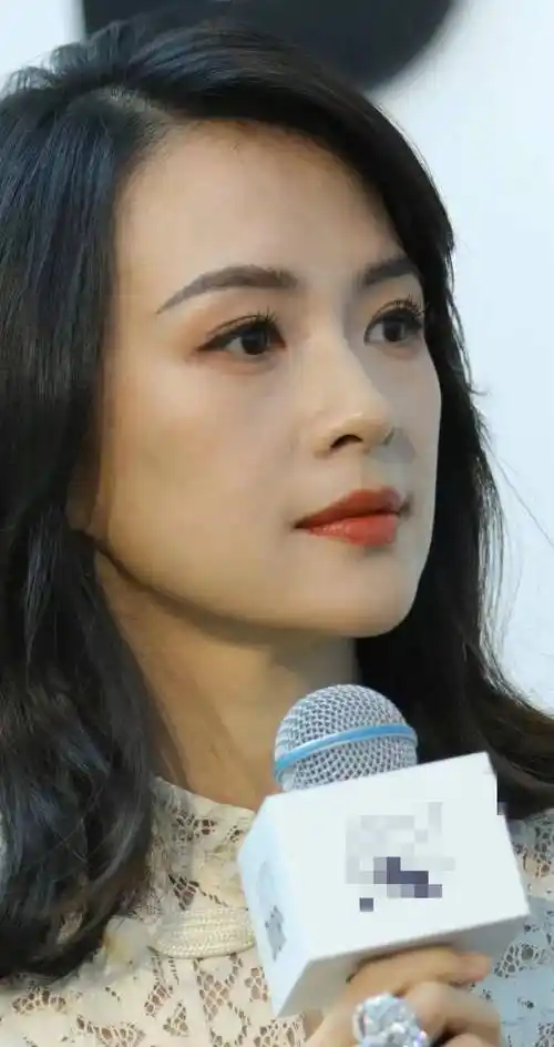 我们先来看章子怡.她身穿白色西装和裙子,留着长发,围着围巾.