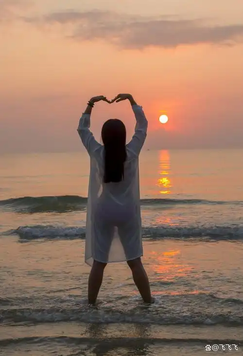 碧波轻拥海之涯, 美女如诗映晚霞. 秀发随风舞翩跹, 眼眸深邃映浪花