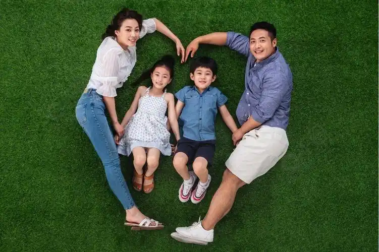 幸福的一家四口躺在草地上组成心形