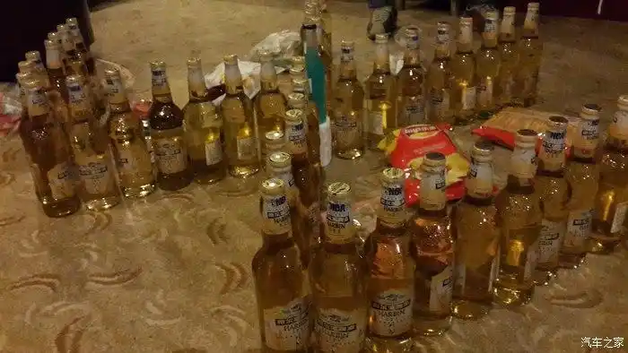 观赛的车友们晚上自己聚会喝酒.用酒瓶摆出大众标志.