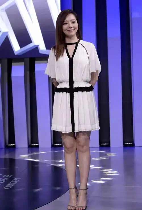 黑色领口与腰带的装饰相呼应,看起来很凸显身材,张靓颖搭配一字带高跟