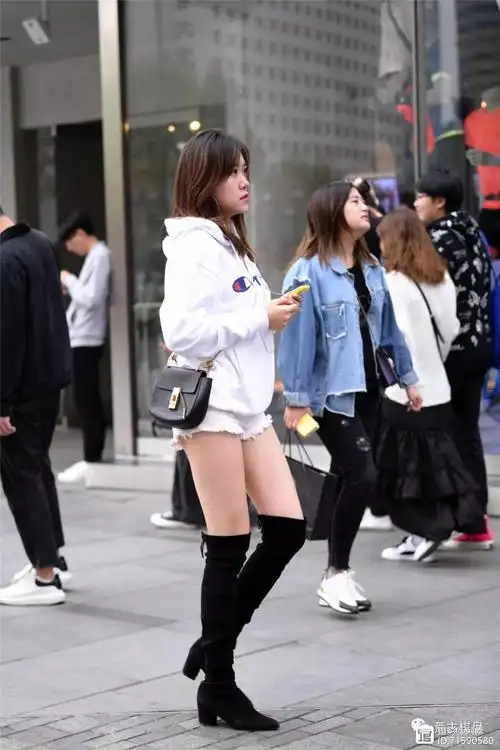 白色牛仔短裤和黑色过膝长靴,搭配出长腿的效果,都说姑娘会搭配