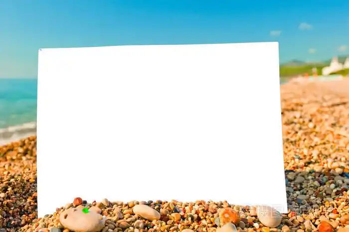 白色张空白的纸在海滩上