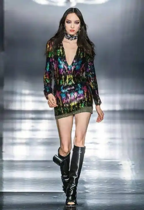 穿着一件拼接色的羽绒外套,这褐色毛衣拼接绿色的外套,下身穿着一条格