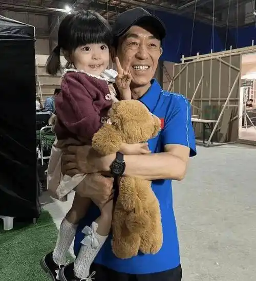 72岁张艺谋现身片场,皮肤黝黑身体结实,抱着小女孩笑容灿烂_林妙可