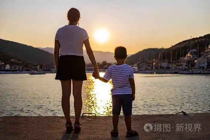 日落时母亲和儿子手牵手