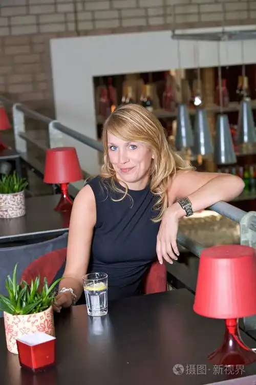 漂亮的金发女人在酒吧里喝酒放松